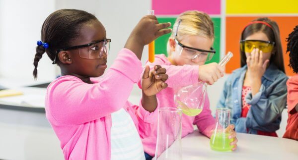 girls in pink doing a chemistry experiment